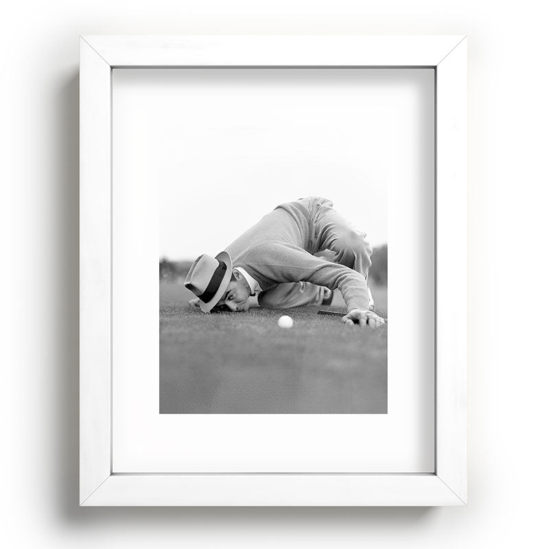Eye to the ground on the 18th hole; golfing man eyes ball to measure distance to hole vintage black and white portrait photograph - photography - photographs poster Framed Art Print Gallery Image 104