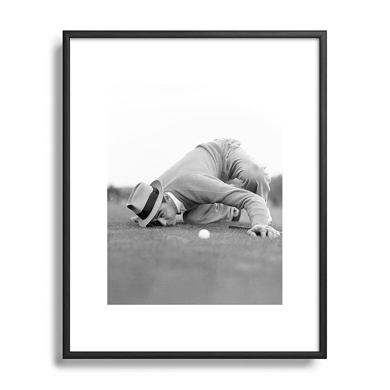 Eye to the ground on the 18th hole; golfing man eyes ball to measure distance to hole vintage black and white portrait photograph - photography - photographs poster Framed Art Print Gallery Image 111